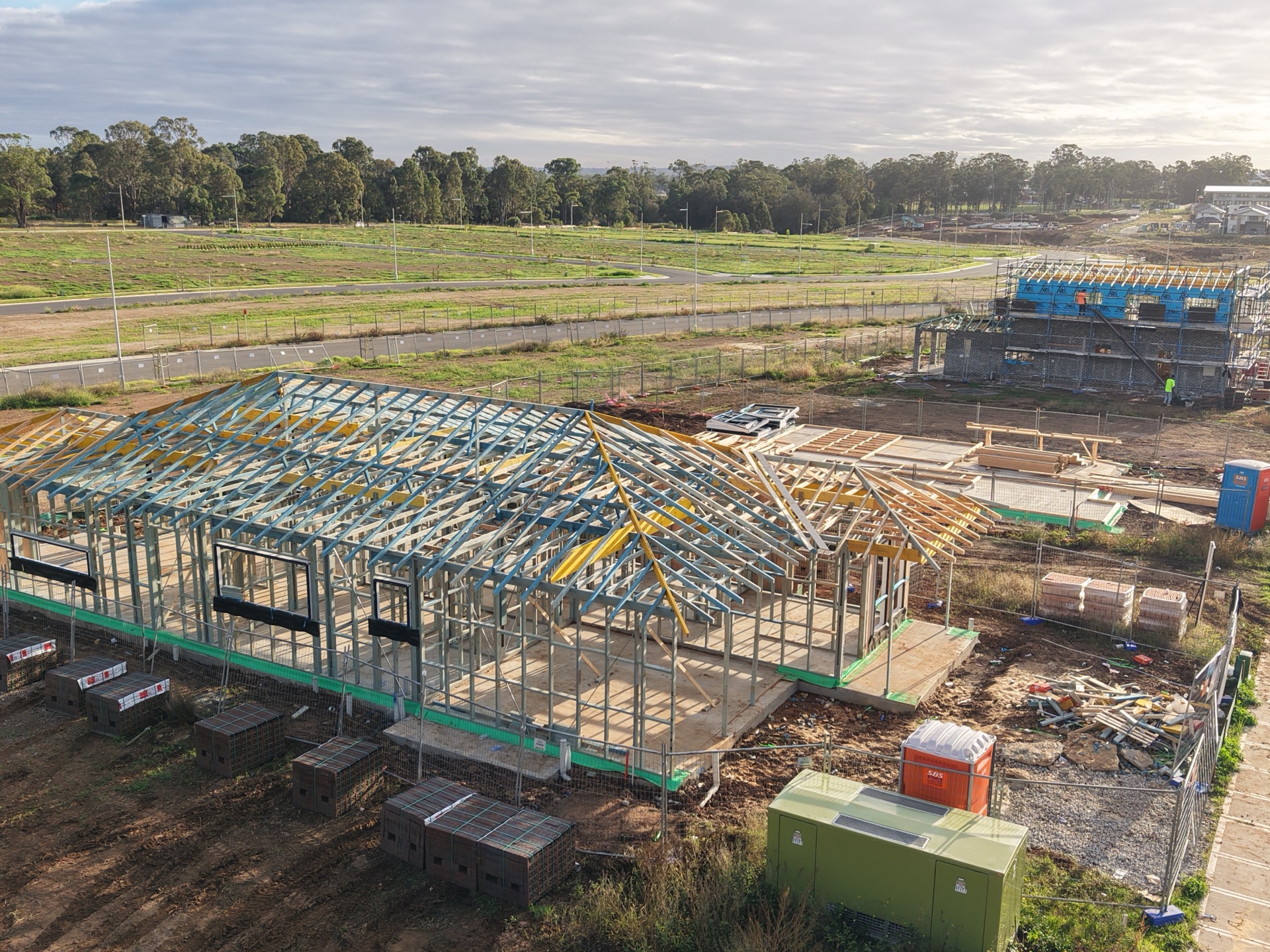 Golden-hour aerial of an AWA Structural Framing steel and timber frame