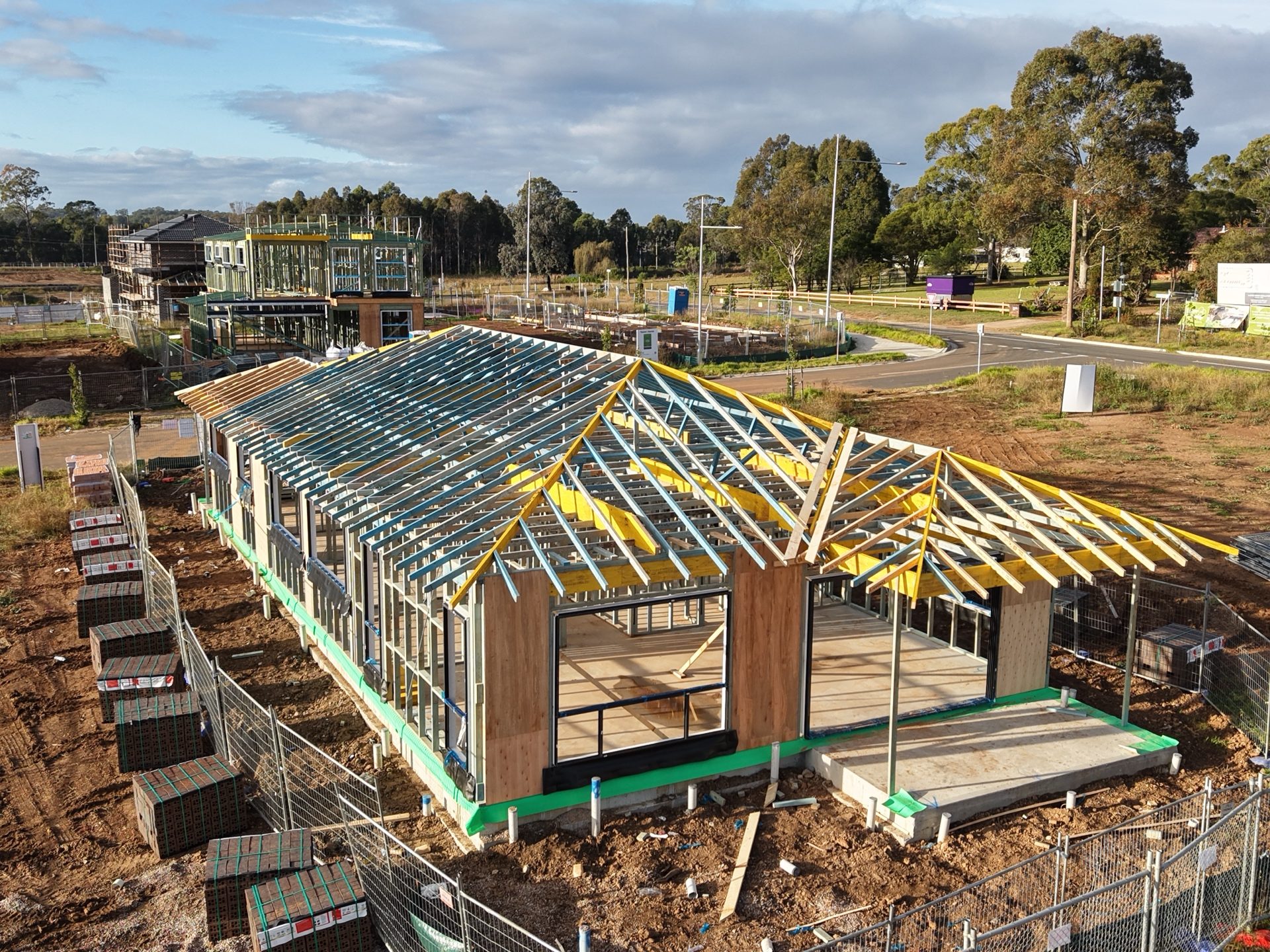 Drone view of completed roof truss framing on a single-storey home with hip roof structure
